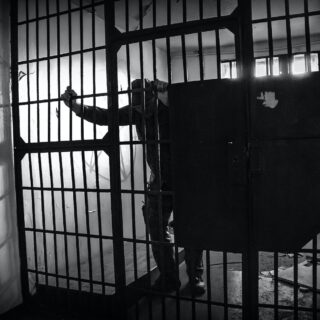 grayscale photo of a prisoner inside the jail